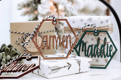 Wooden hex name ornament with cursive “Tammon” engraving, dark green outline, twine loop