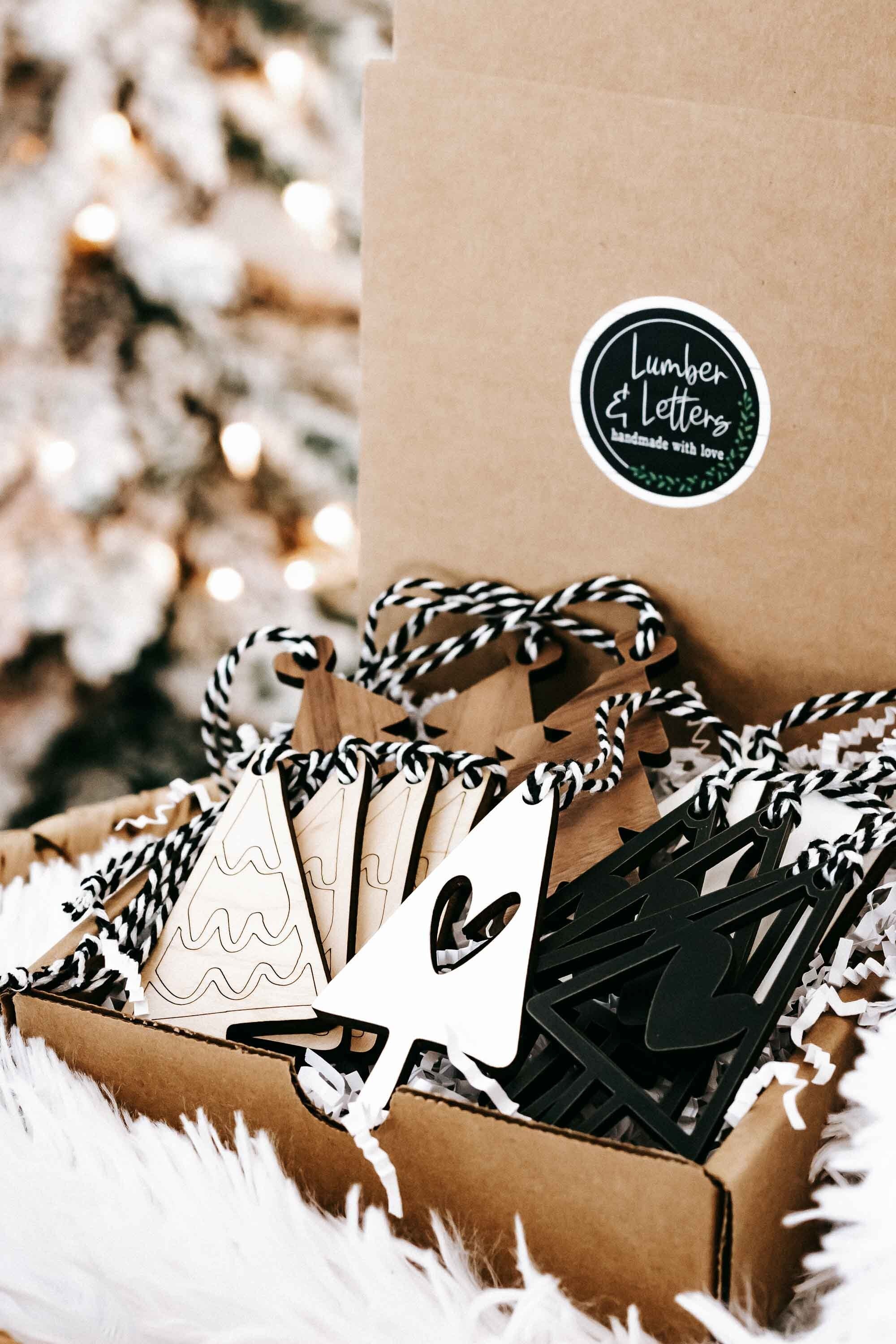 Boho Christmas ornaments in kraft packaging with striped rope hangers, tree shapes and heart cutouts