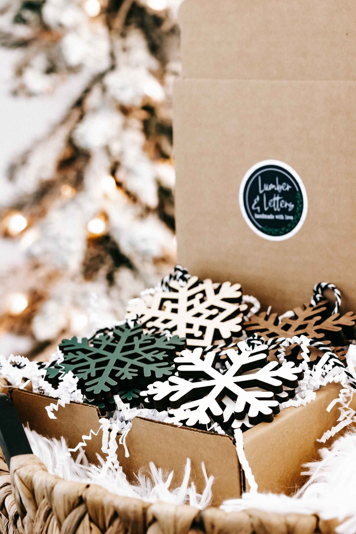 Set of snowflake wood Christmas ornaments with white and green pieces in a gift box
