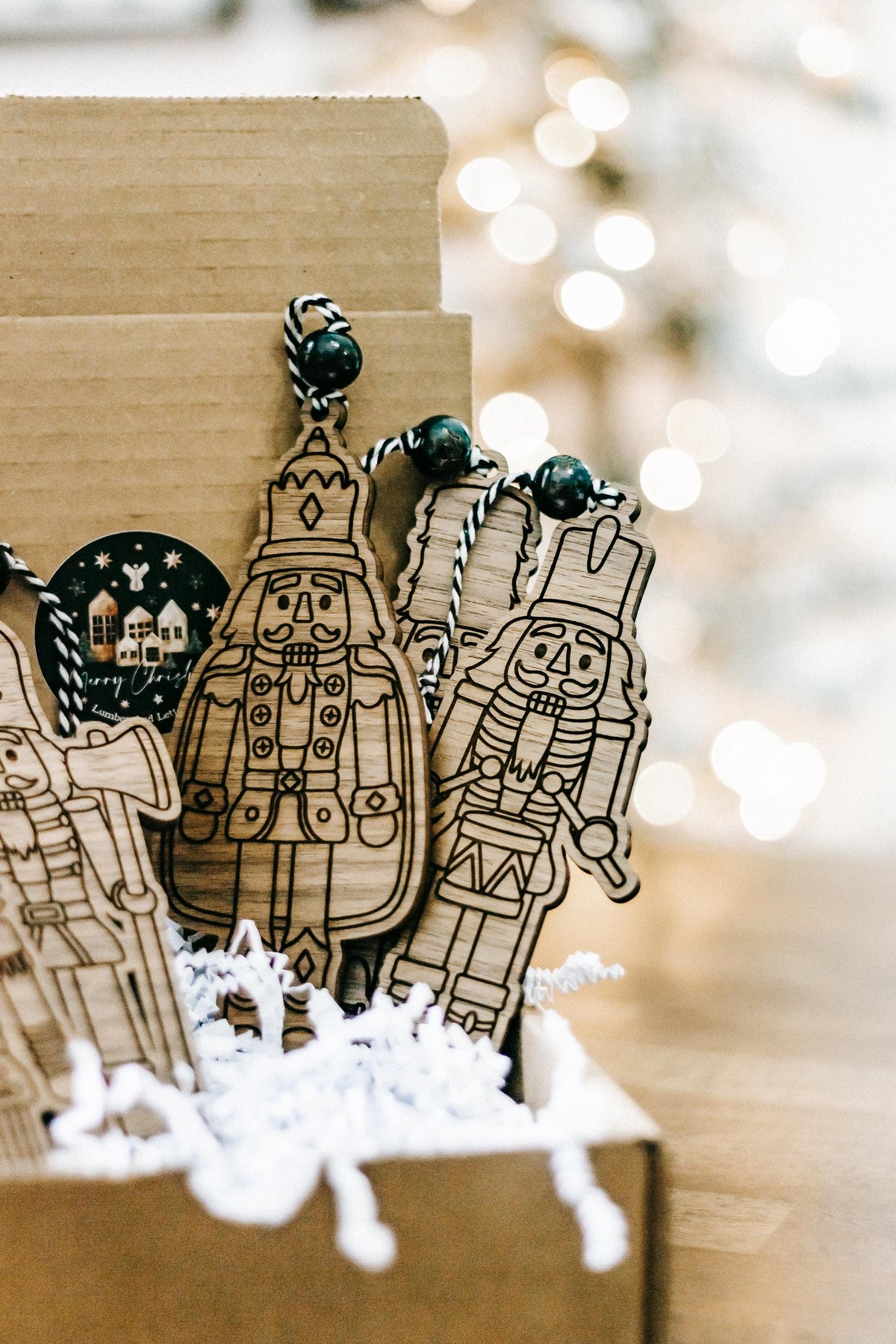 Engraved wooden nutcracker ornaments in a gift box with dark bead hangers