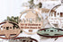 Round wooden Christmas keepsake ornament with house cutouts, hanging loop, and year