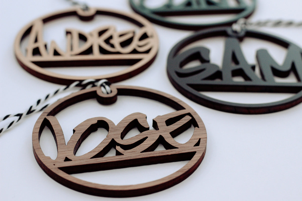 Wooden laser-cut custom name ornaments with hanging loops, dark and light wood set