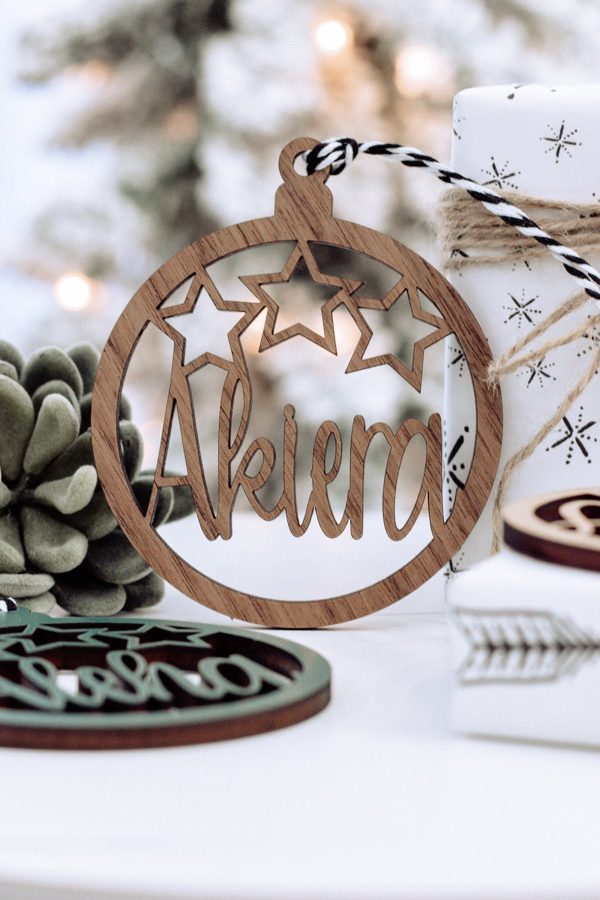 Brown wooden round name ornament with star cutouts and arched engraved name