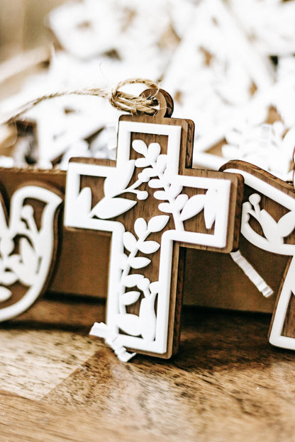 Close-up of white floral cutout cross Christmas ornament with hanging twine, set of 10