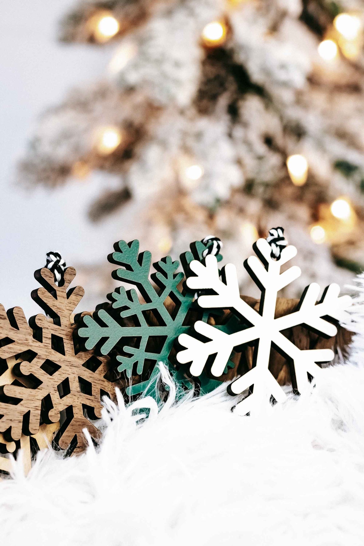 Close-up set of snowflake wood Christmas ornaments in white, dark green, and brown