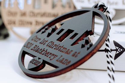 Oval wooden Christmas keepsake ornament with laser-cut house and year lettering