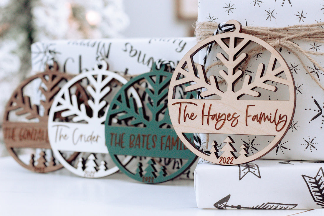Round engraved family name Christmas ornament with tree cutout, light wood and dark outline