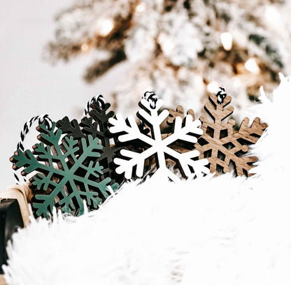Set of wooden snowflake ornaments in dark, white, green, and natural wood accents