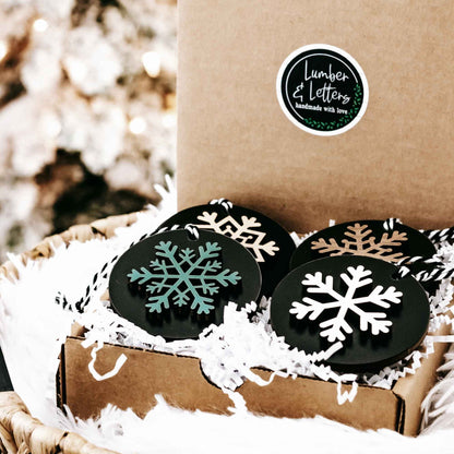 Set of 8 black wooden snowflake ornaments with white and gold snowflake designs