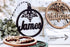 Round wooden name ornament with snowflake cutout and dark lettering on white