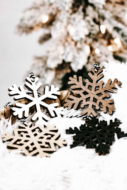 Wood snowflake ornament set close-up: white, tan, and dark snowflake cutouts