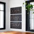 Wall decor sign set with three dark panels reading Wash, Dry, Fold in cursive script