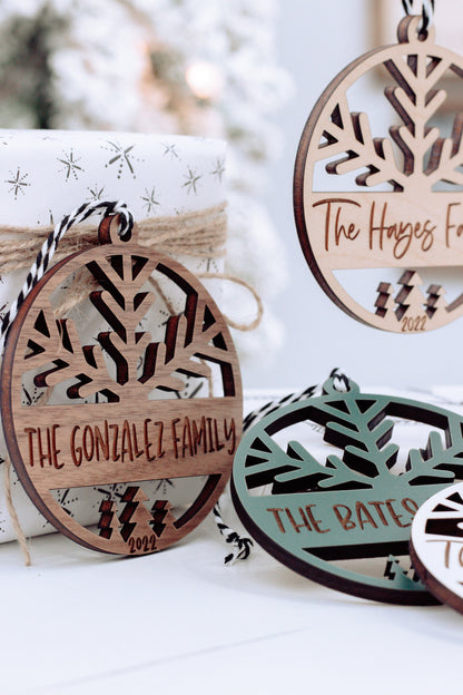 Engraved round ornament with tree cutout and family name, green and light wood versions