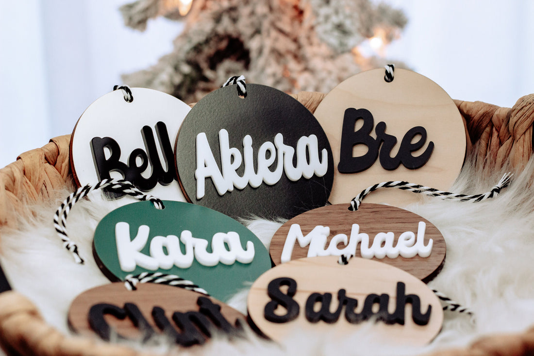 Round wooden name ornaments with rope hangers and teal, black, and tan lettering