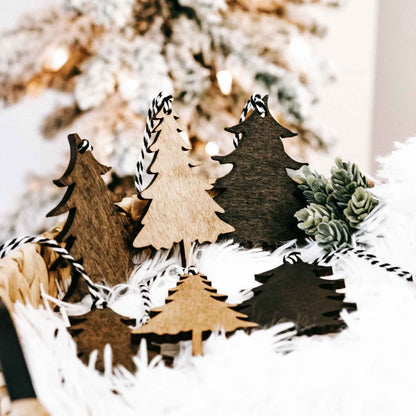 Set of rustic wooden Christmas tree ornaments with black-and-white striped hanging loops.