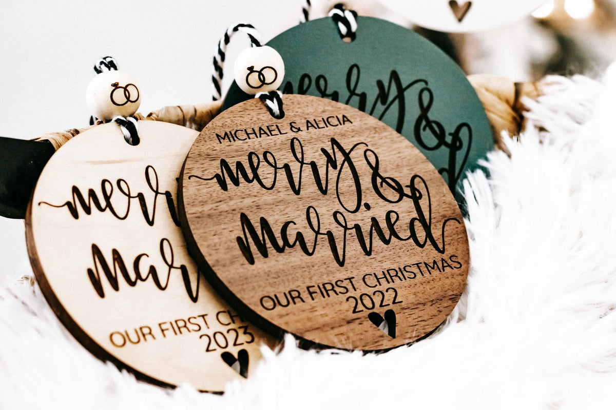 Green and wood round “Merry &amp; Married” Christmas ornaments with “Our First Christmas 2022”