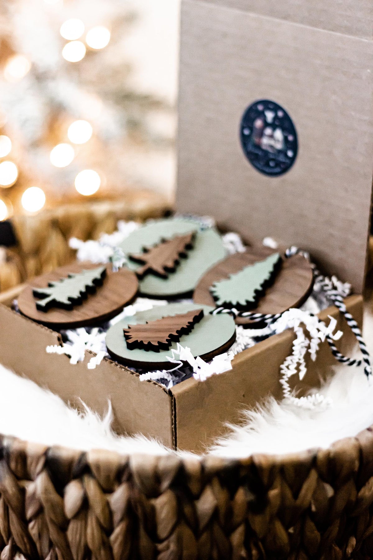 Set of wooden Christmas tree ornaments with striped hanging cords in a gift box