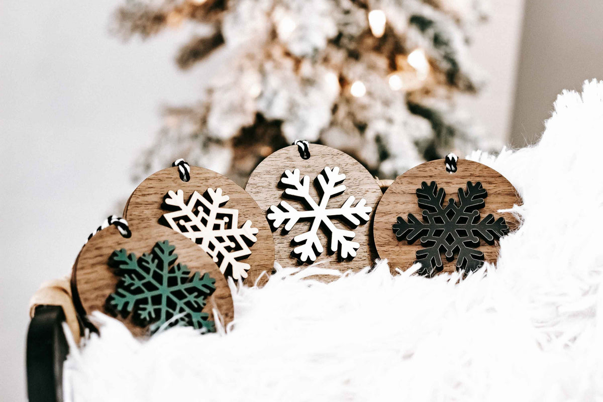 Wooden snowflake ornaments set with round wood backs, striped hanging loops and mixed colors