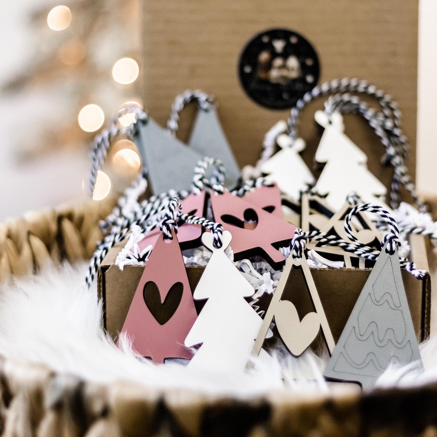Wooden Christmas tree and house ornaments with heart cutouts in blush, white, and gray