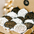 Set of engraved Christmas ornaments in black and white, in a gift box on a table.