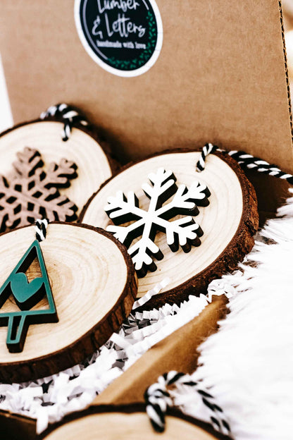 Wood slice ornaments with snowflake and tree designs, set with string loops