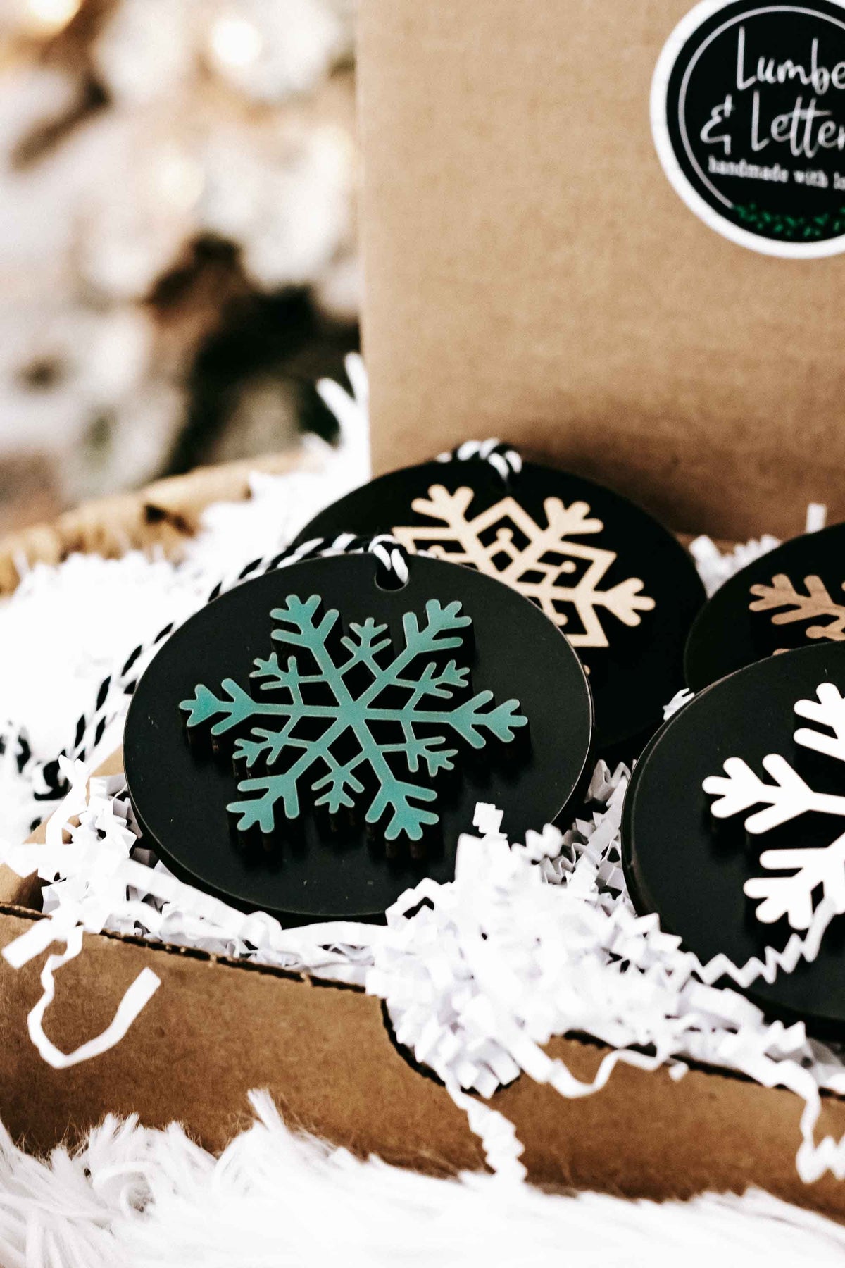 Set of 8 black wooden snowflake ornaments with white, green, and gold snowflake prints