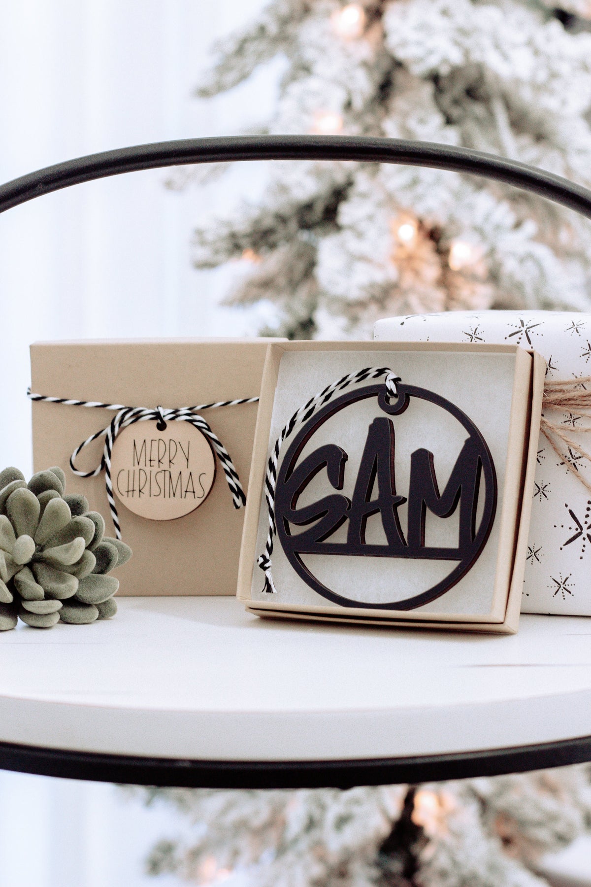 Wooden custom name ornament in open gift box, black engraving on round tag