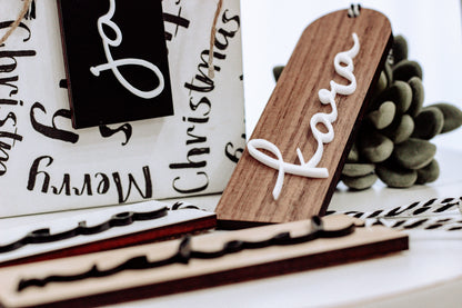 Personalized wooden stocking tag with white name script on dark and walnut boards