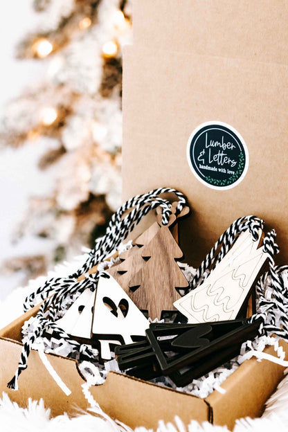 Kraft gift box of boho Christmas tree ornaments with striped rope hangers and tree/heart cutouts