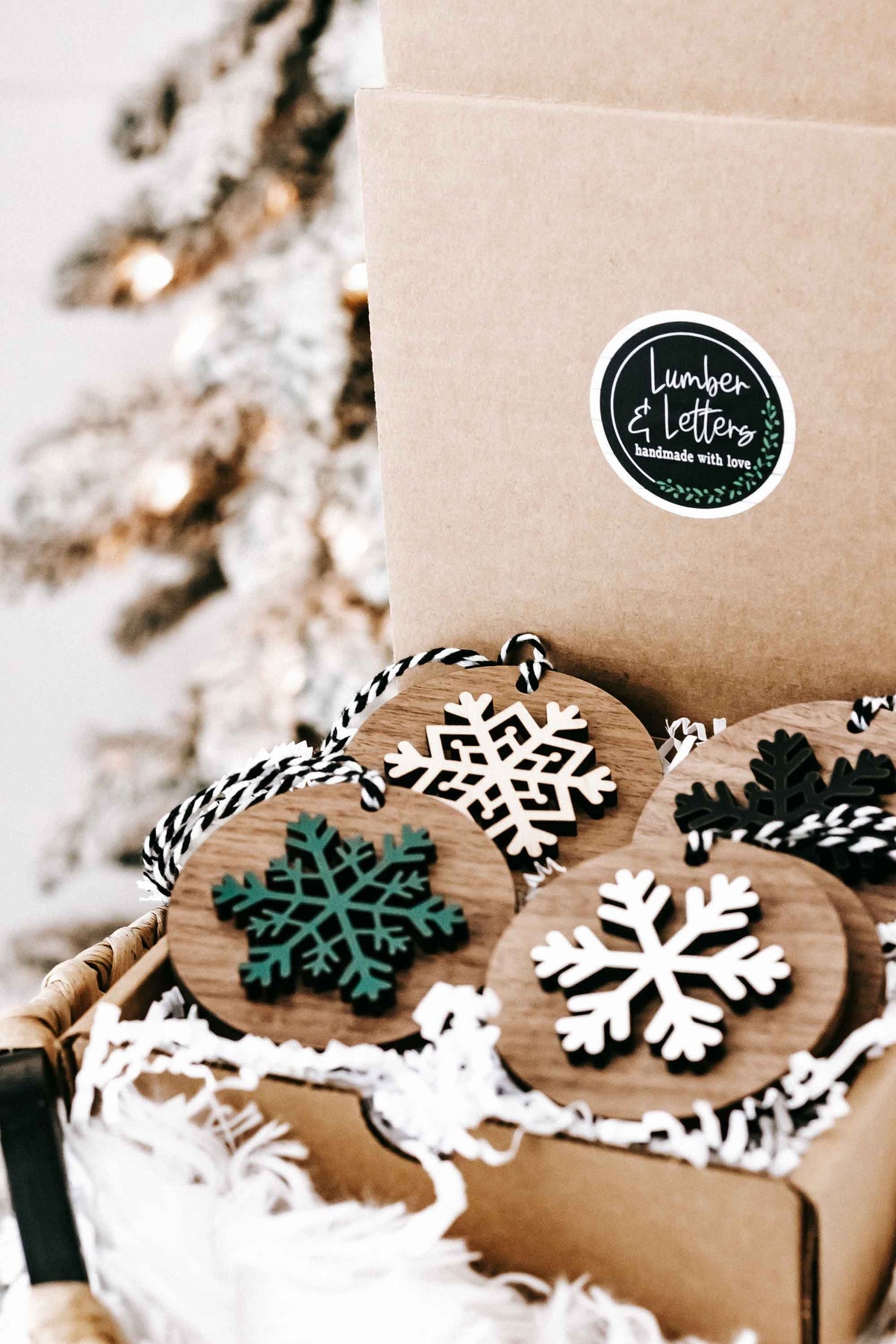Wooden snowflake tree ornaments set with striped hangers, white, green, and dark designs