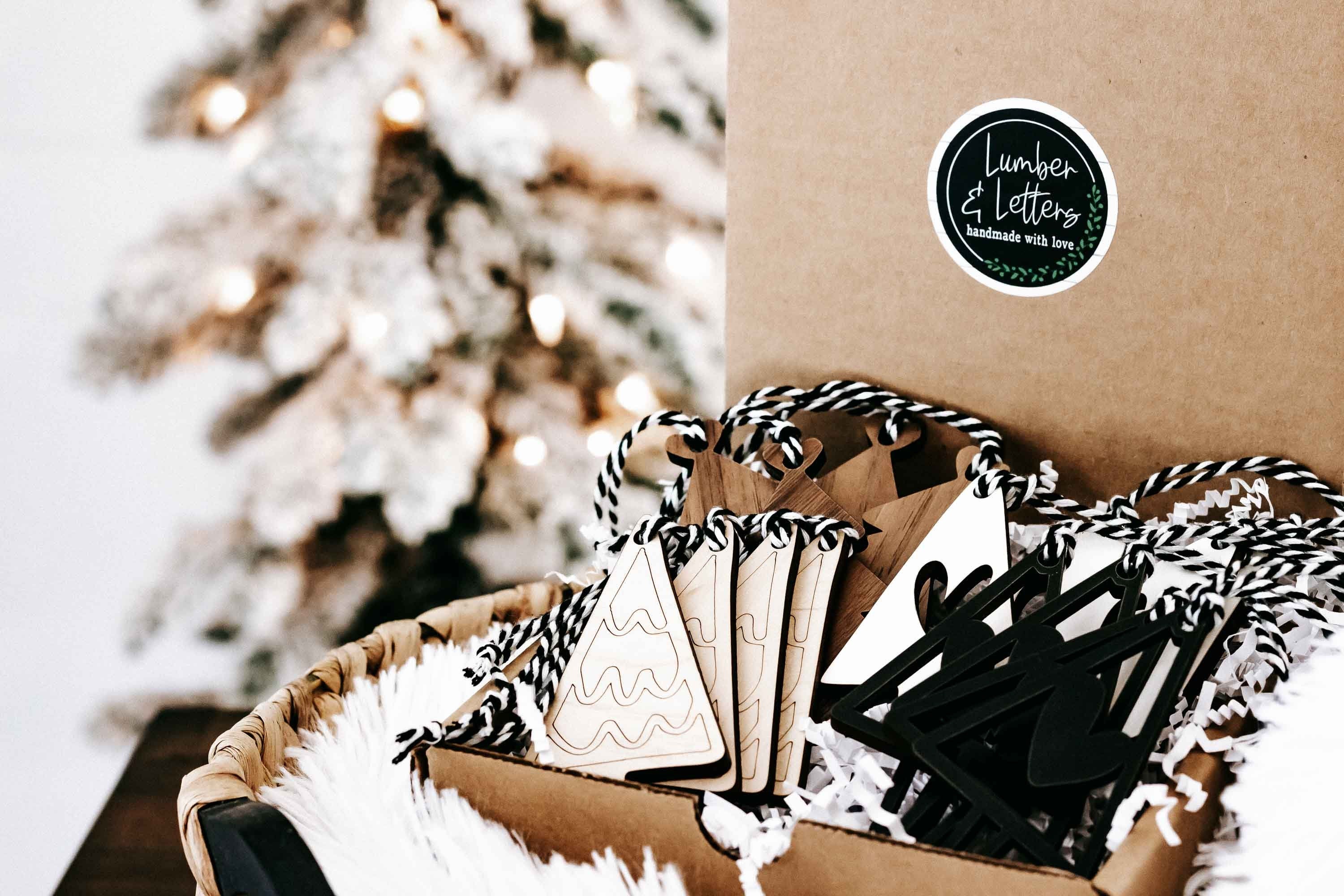 Boho Christmas ornaments in a kraft box with striped cord hangers, including tree and heart shapes