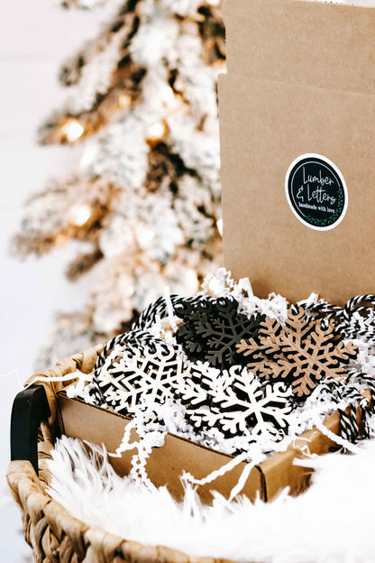 Snowflake wooden ornaments in a kraft box with white faux fur and mixed black and beige designs