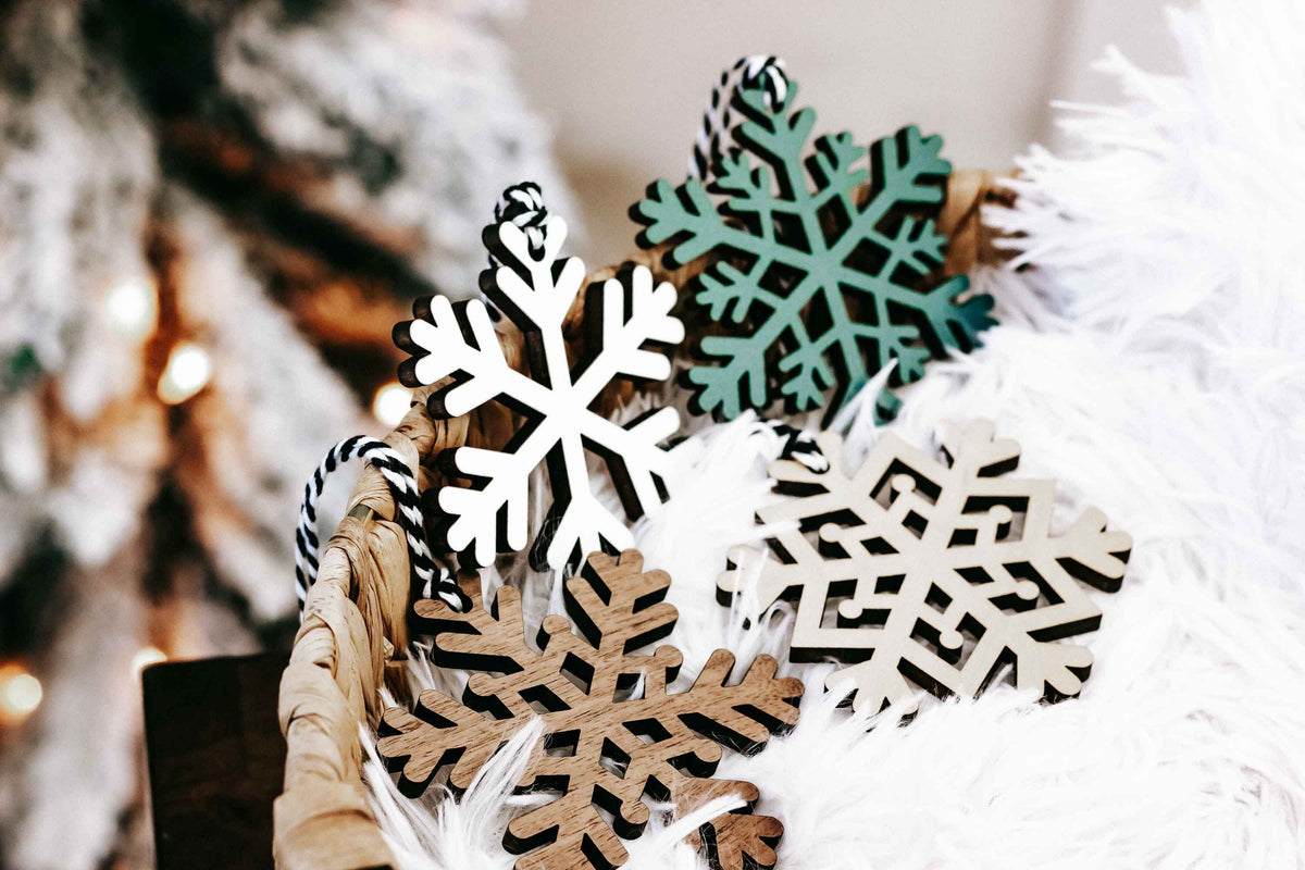 Set of snowflake wood Christmas ornaments resting on white faux fur