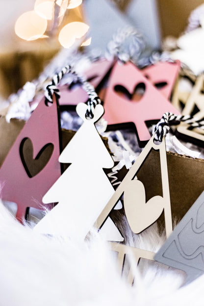 Blush pink and white wooden Christmas tree ornaments with heart cutouts and loop hangers