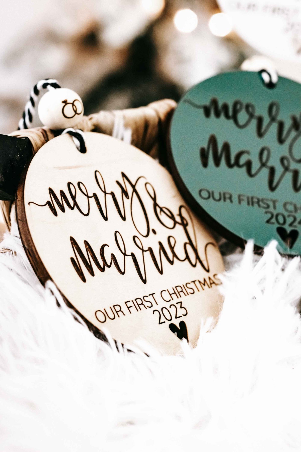 Green and light-wood round Christmas ornaments with “Merry &amp; Married” and year text