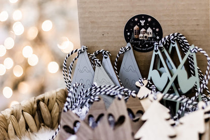 Set of 16 boho wood Christmas ornaments with black, white, and sage accents and tree cutouts
