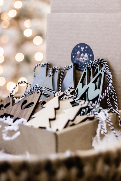 Set of 16 boho wood Christmas ornaments in a box, featuring tree shapes and zigzag patterns