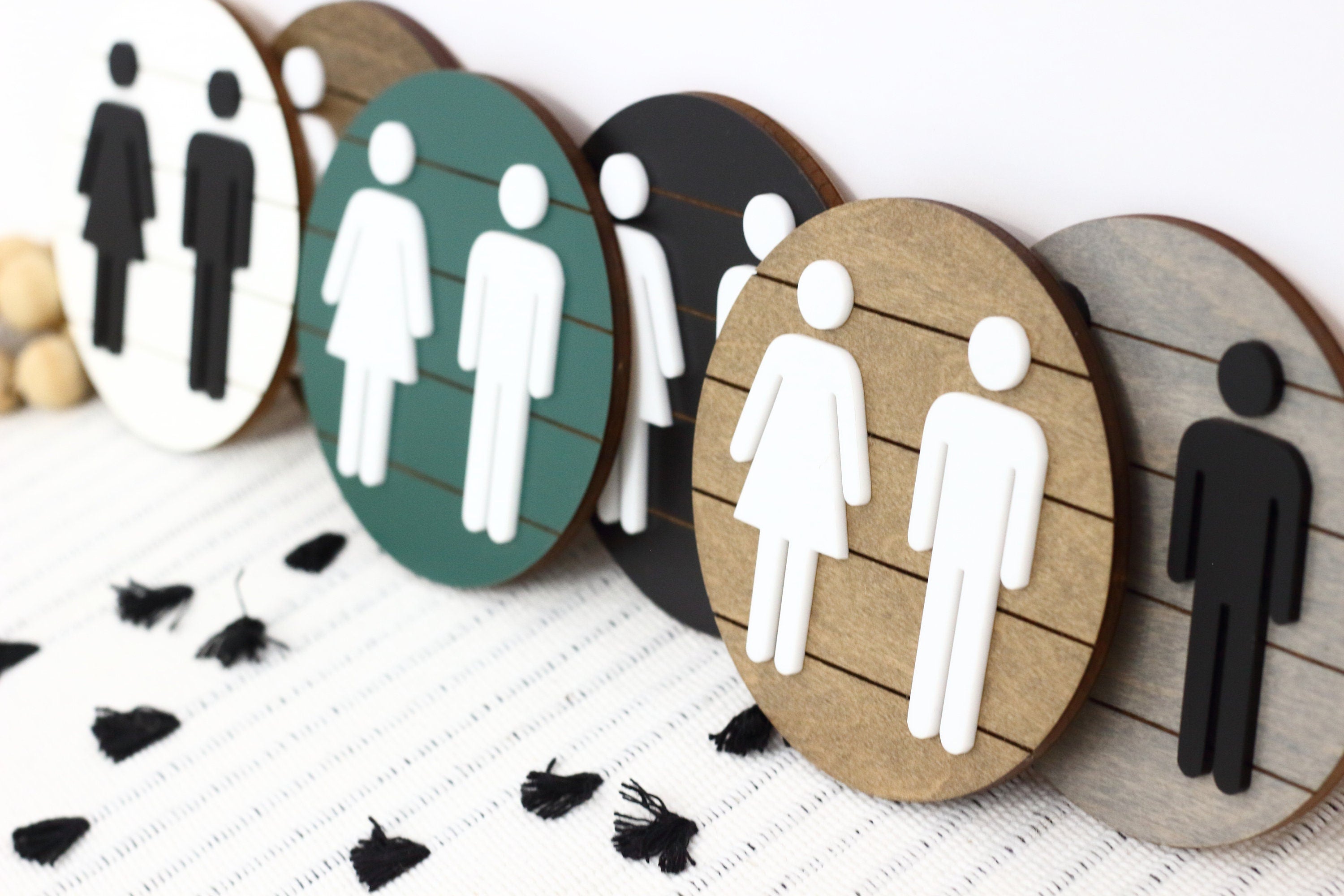 Assorted round 3D restroom accessibility signs with male, female, and wheelchair icons