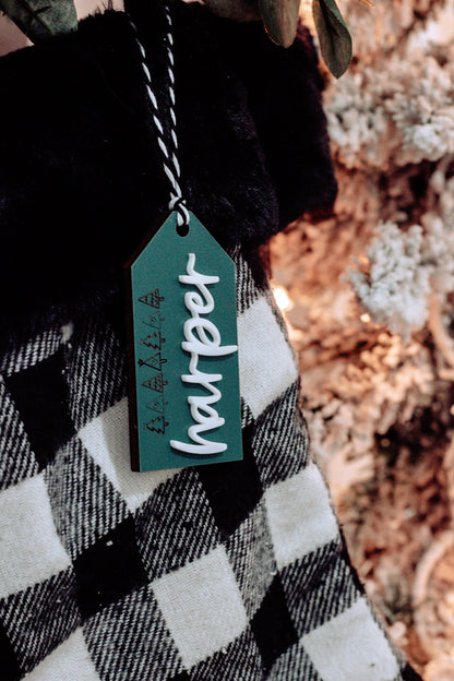 Close-up of teal stocking tag with white name &