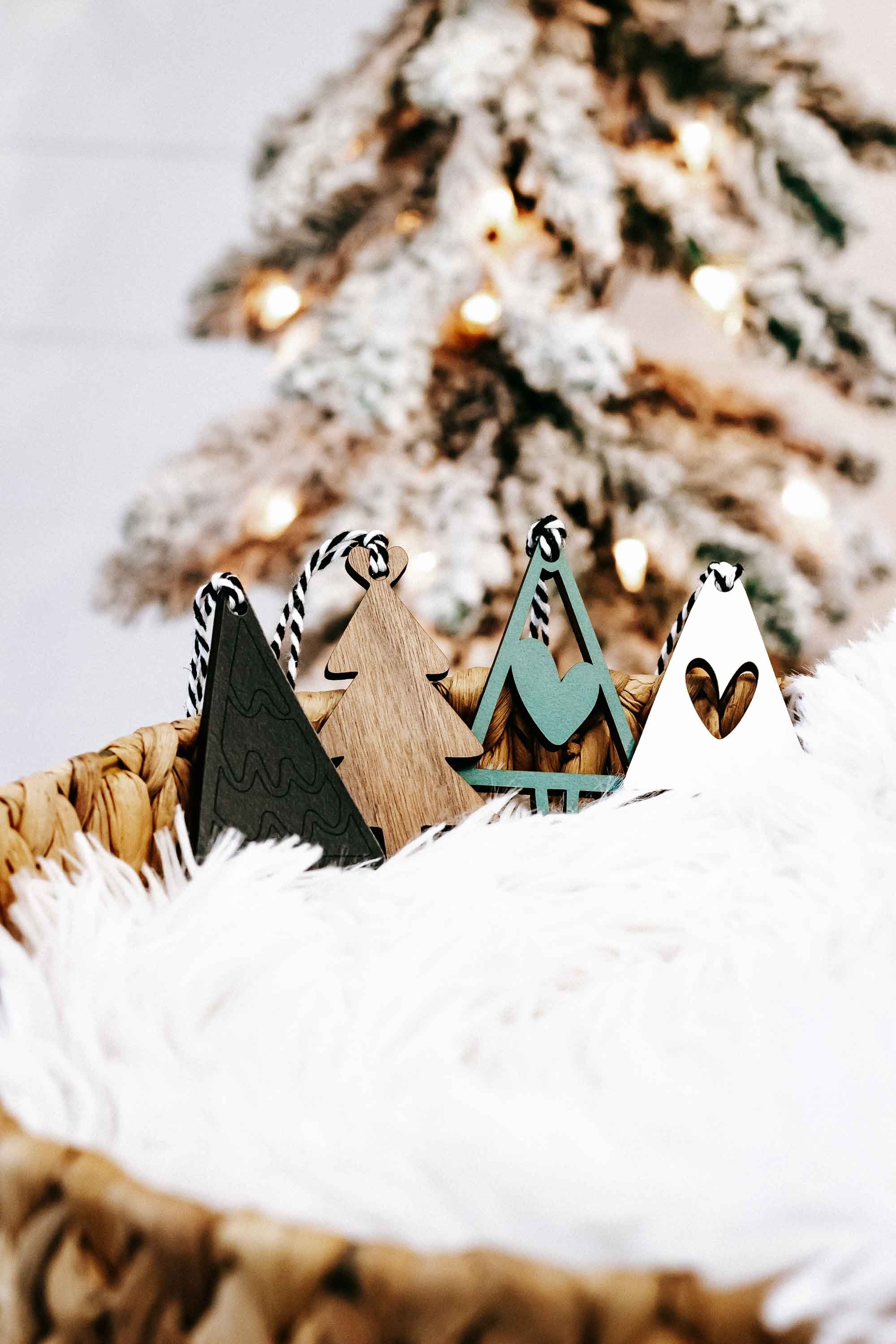 Set of wooden Christmas tree ornaments in natural wood and dark green with striped rope hangers
