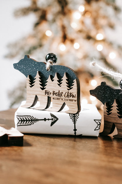 Bear cabin ornament with dark glitter bear, engraved pine trees, and cabin lettering
