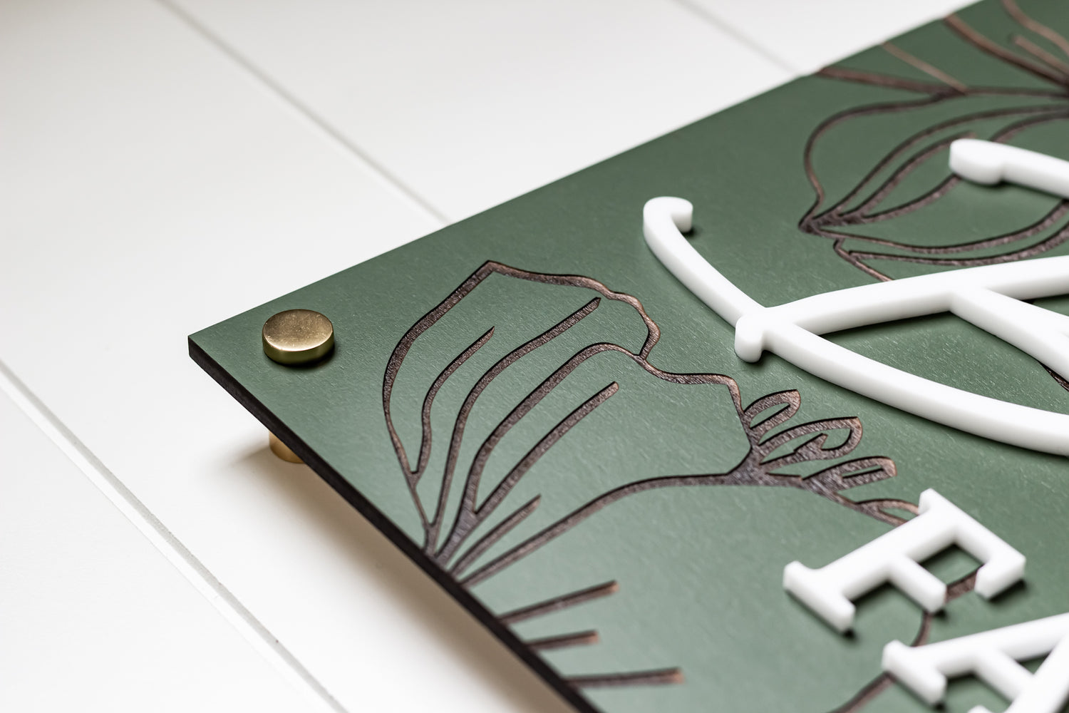 Green rectangle name sign corner with bronze screw cap and floral outline engraving