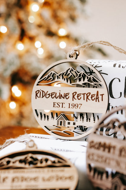 Engraved circular wood cabin ornament with “Ride... Retreat” and “EST. 1997”, rope loop