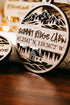 Close-up round engraved wood ornament reading “Summit Ridge Cabin” with coordinates