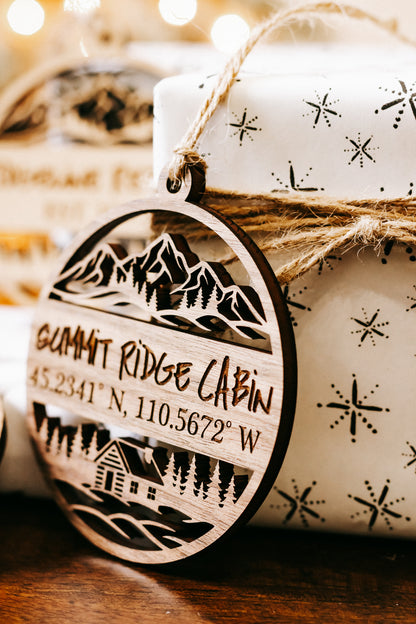 Close-up round engraved wood ornament with “Summit Ridge Cabin” and coordinates