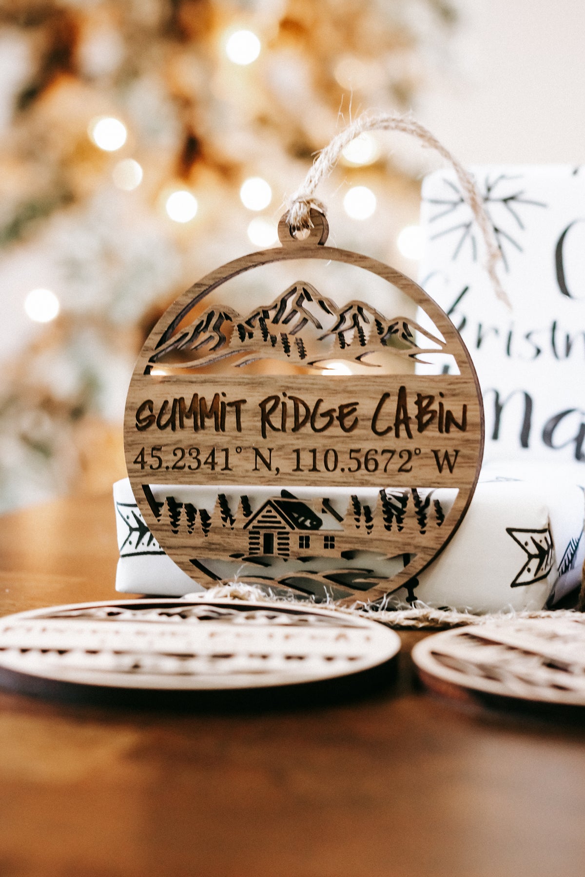 Engraved circular wood cabin ornament reading “SUMMIT RIDGE CABIN” with coordinates