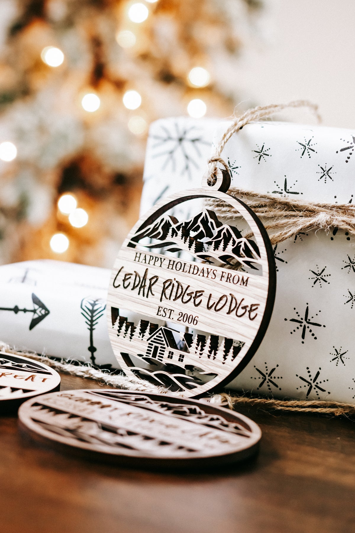 Engraved round wood ornament reading “Happy Holidays from Cedar Ridge Lodge”