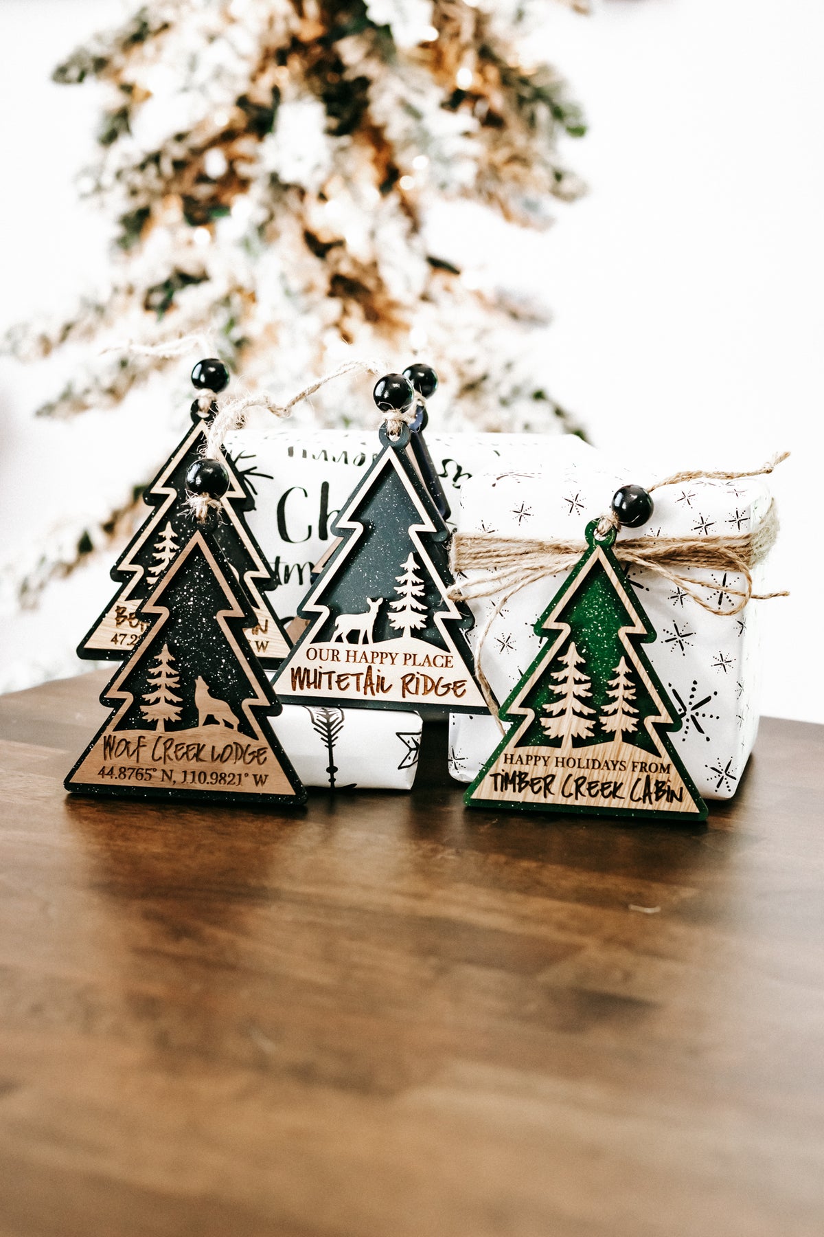 Group of wooden lodge tree ornaments with hanging beads, twine strings, and dark green finish.