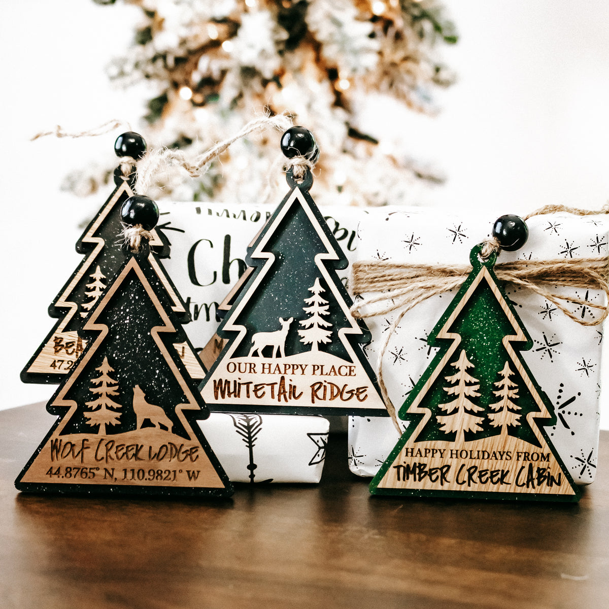 Multiple hanging tree-shaped cabin lodge ornaments with bell-style tops