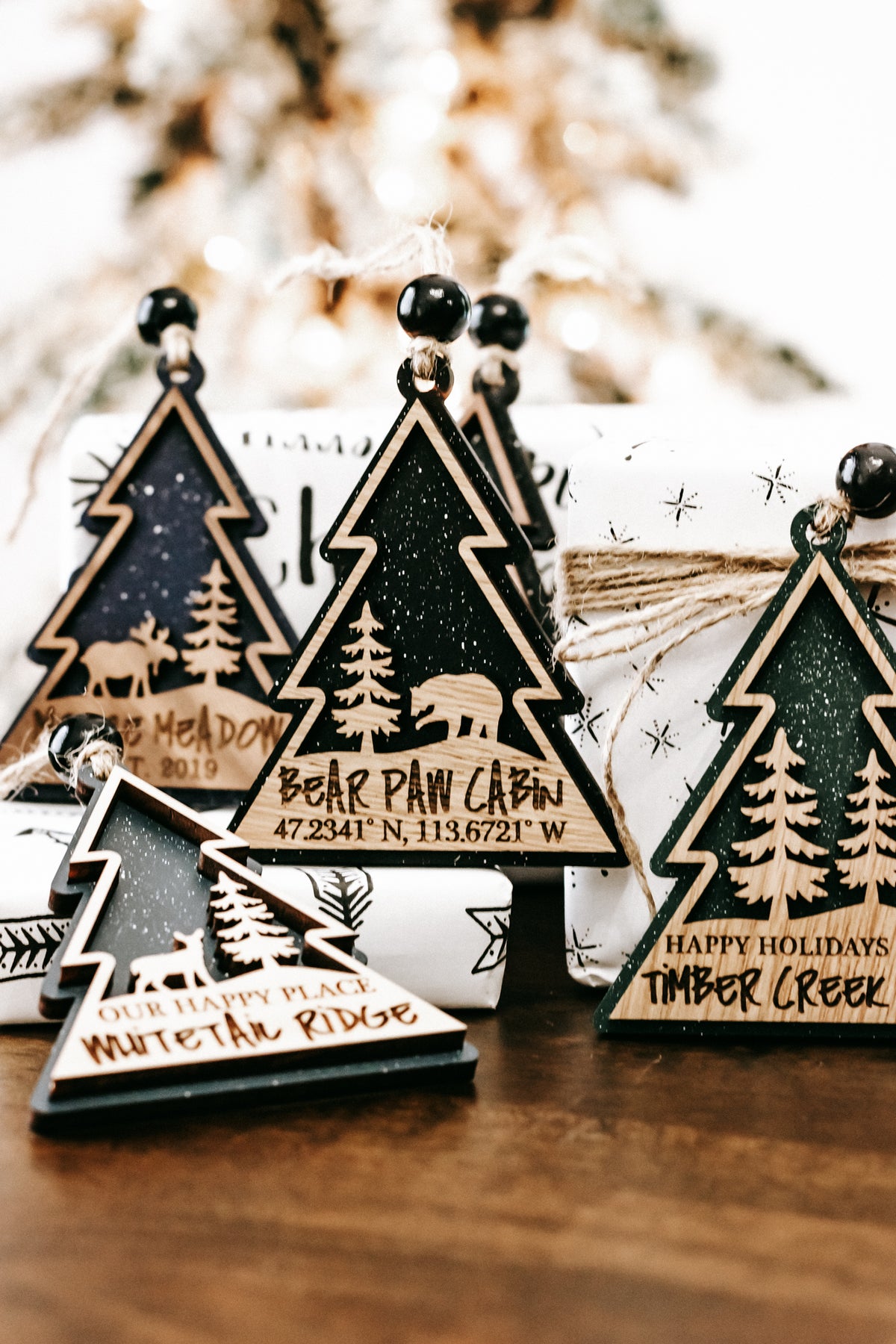 Multiple wooden tree ornaments with hanging beads on twine, dark green centers, gold borders.